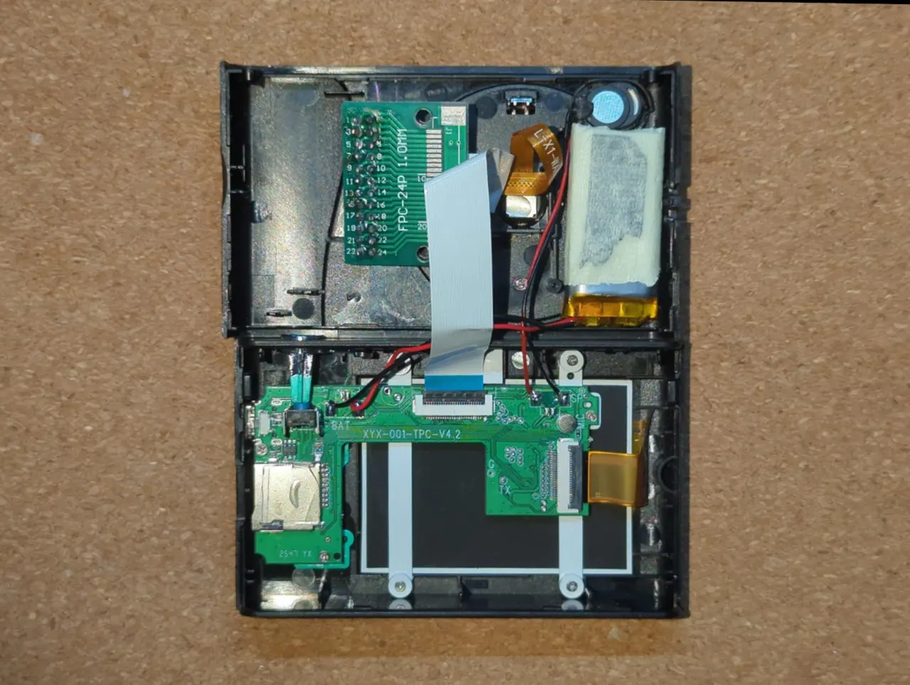 Photo of the internals of the toy camera, with the patchboard connected between the sensor and the PCB