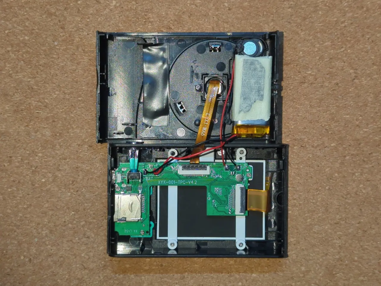 Photo of the internals of the toy camera, with the battery relocated on the right